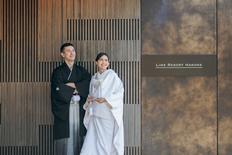 ライムリゾート箱根のエントランスに立つ新郎新婦