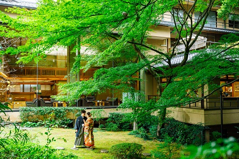 旅館の庭園で撮影する新郎新婦